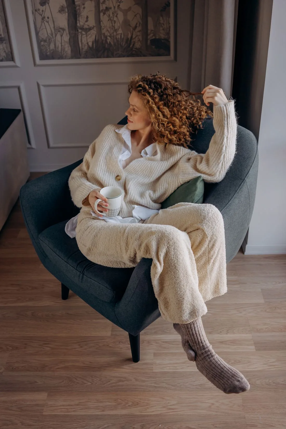 Woman in a cosy lounge set holding a warm drink